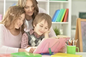 A mother and her two children are enjoying the hotel's babysitting service while reading a book.