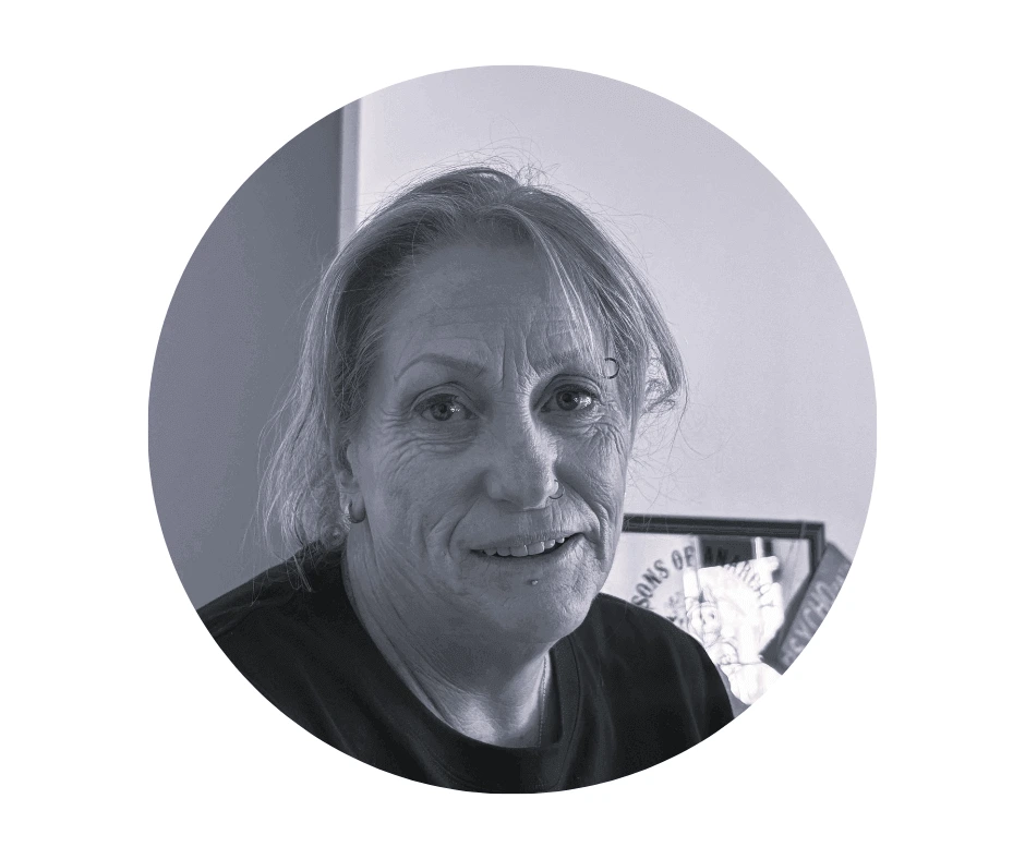 Meet our Babysitters A Cherished Cherubs Babysitter with light hair pulled back, wearing a dark top, sits indoors and looks toward the camera with a neutral expression, capturing the calm presence often found in Cherished Cherubs portraits.