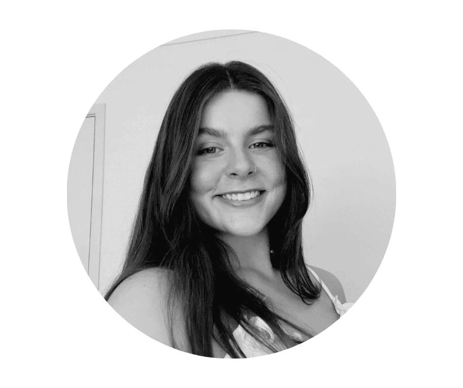 Black and white portrait of a young Cherished Cherubs Babysitter with long hair, smiling at the camera inside a circular frame—a timeless capture by Cherished Cherubs.