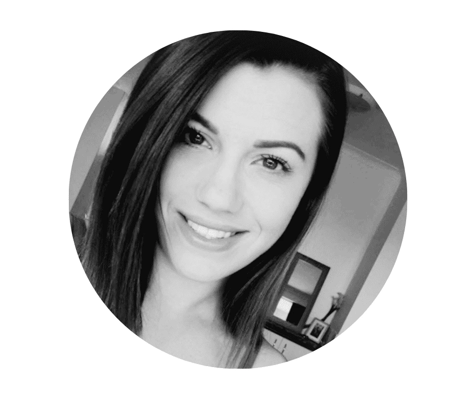 A Cherished Cherubs Babysitter with straight dark hair smiles at the camera in a black and white Cherished Cherubs portrait, with a room and furniture visible in the background.